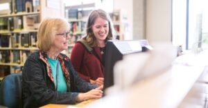 young and older woman on library computer